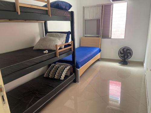 a bedroom with two bunk beds in a room at Apto no Canto do Forte com garagem in Praia Grande