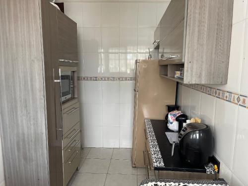 a small kitchen with a black counter in it at Apto no Canto do Forte com garagem in Praia Grande