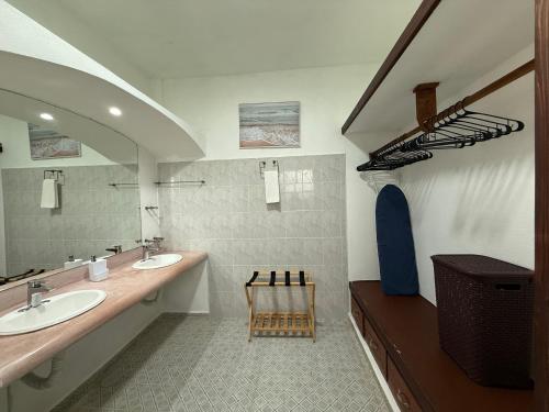 a bathroom with two sinks and a wooden chair at VISTAMAR Casa a pie de Playa in Playa Agua Blanca