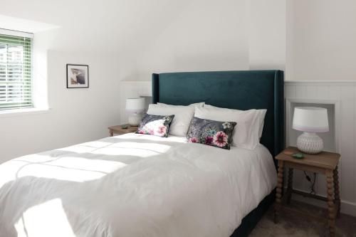 a bedroom with a large white bed with pillows at Sunray Cottage in Weymouth