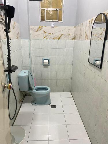 a bathroom with a toilet and a mirror at AJM Iligan Homestay in Saray