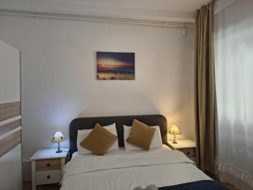 a bedroom with a bed with two tables and two lamps at Studio Nice in Old Town Tonitza in Bucharest