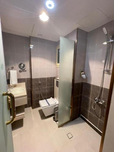 a bathroom with a shower and a toilet and a sink at Smayah Residence Hotel in Riyadh