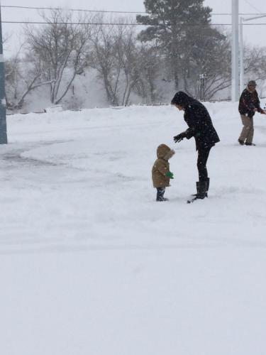 a man and a child playing in the snow at El Rancho Motel in Williams
