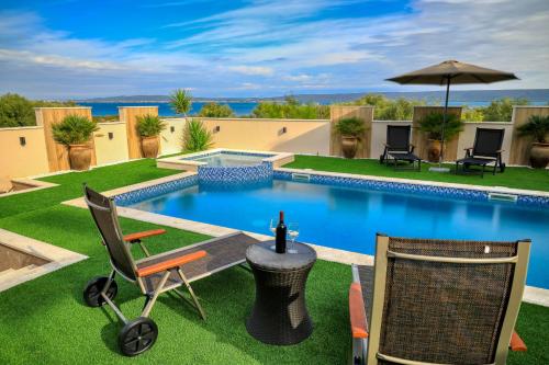 a backyard with a pool with chairs and an umbrella at Masanda in Ždrelac