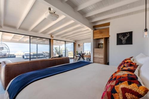 a bedroom with a large bed and a large window at Atomic Ranch by Fieldtrip Secluded Pool Views in Pioneertown