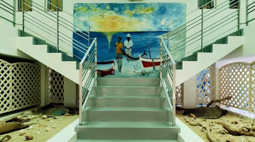 a staircase in a building with a painting on the wall at Pensão Big Game Maio Vila do Maio in Vila do Porto