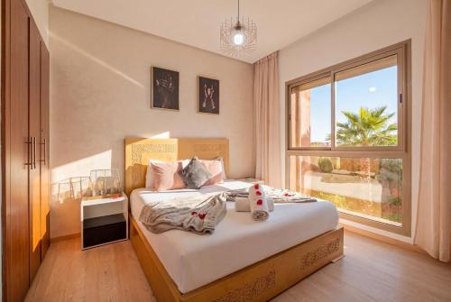 a bedroom with a bed with a large window at Prestigia Family Luxury Apartments in Marrakesh