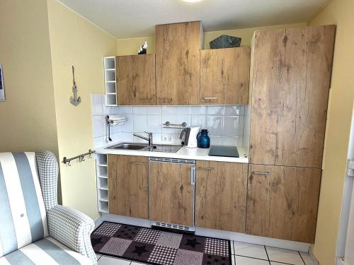 a small kitchen with wooden cabinets and a sink at Stettiner Str 6c in Grömitz