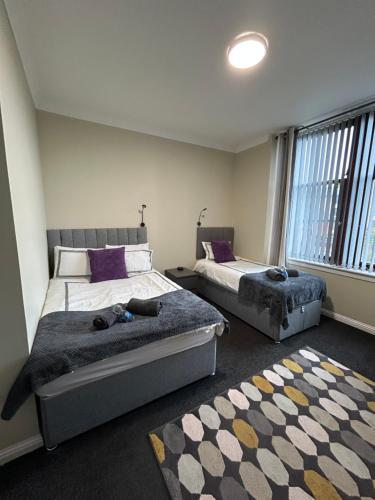 a bedroom with two beds and a rug at Spacious one bedroom flat, entire property. in Greenock