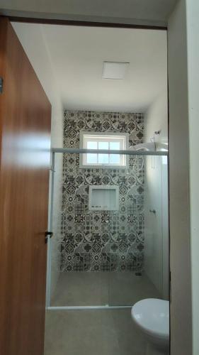 a bathroom with a shower with a toilet and a window at Pouso do Rancho in São José do Barreiro