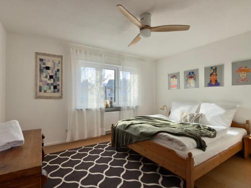a bedroom with a bed and a ceiling fan at Haus zum Ordenswald in Neustadt an der Weinstraße