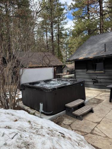 a hot tub and a bench in front of a house at The Hideaway Big Bear in Big Bear Lake