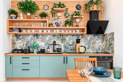 a kitchen with blue cabinets and plants on the wall at Boho Dream Apartments in Ulcinj
