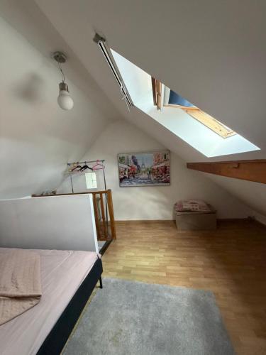 a attic room with a bed and a skylight at Homewood - entire property for 6 people - 4 adults maximum - in village 10 min from Disneyland Paris & TGV RER A in Montry