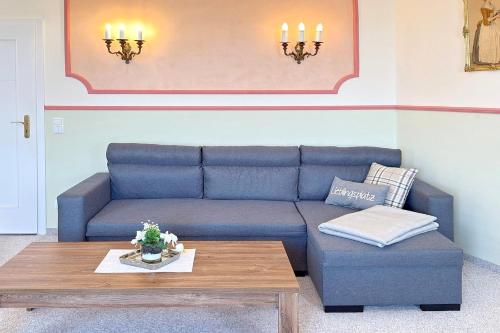 a living room with a blue couch and a coffee table at Zach Family in Lübbenau