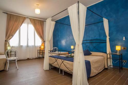 a bedroom with two beds and a blue wall at Hotel Noto Marina Scirocco & SPA in Noto Marina