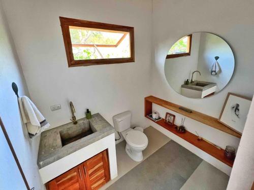 a bathroom with a sink and a toilet and a mirror at Casa Isla - Private Retreat in Galapagos in Puerto Baquerizo Moreno