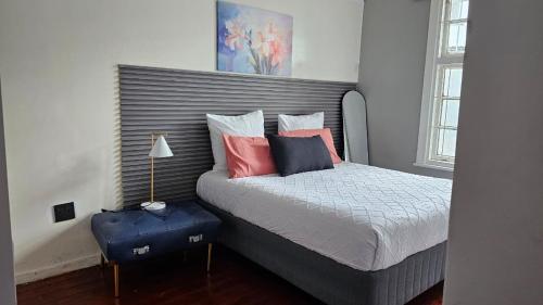 a bedroom with a bed with pink and blue pillows at Jacaranda Escape in Pretoria