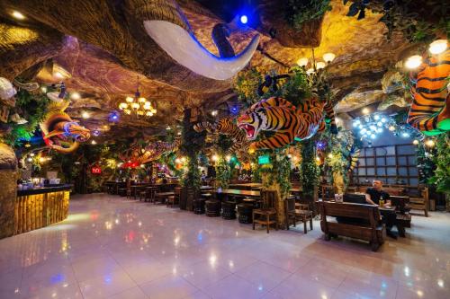a restaurant with a ceiling decorated with plants and animals at Tiger Complex Patong in Patong Beach