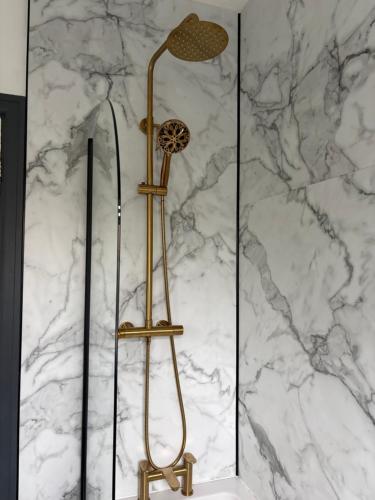 a shower in a bathroom with a marble wall at Little Yacht Inn in Penzance