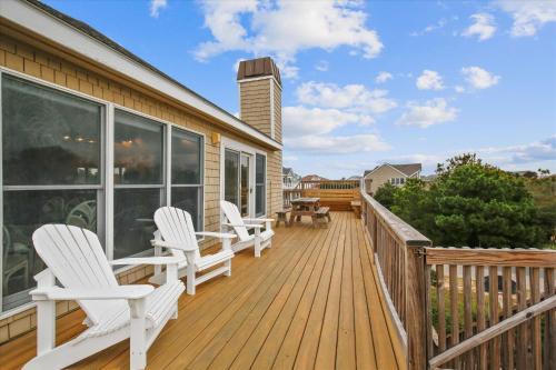 a deck with white chairs on a house at 1067 - Easy Street in Corolla