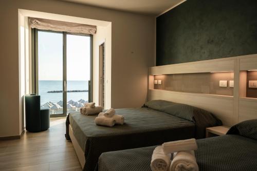 a bedroom with two beds and a view of the ocean at Hotel La Bussola in Ortona