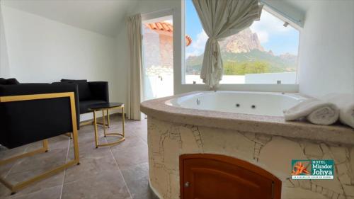 a bathroom with a tub with a view of a mountain at Mirador Johya Hotel in Bernal
