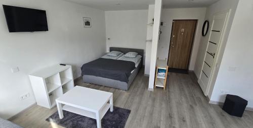 a small bedroom with a bed and a tv at Anykščiai Center Apartment in Anykščiai
