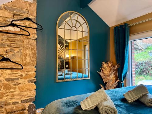 a bedroom with a blue wall and a mirror at Travel Wood in Waulsort