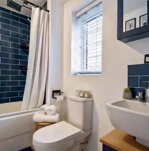 a white bathroom with a toilet and a sink at Your Versatile Luxury - Space for All- Sleeps 10 in Bedford