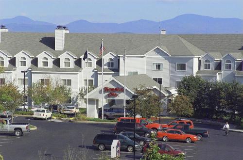 a large white building with cars parked in a parking lot at Hampton Inn Burlington - Colchester in Burlington