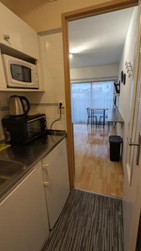 a kitchen with a sink and a microwave and a table at T1 curistes et vacances in Dax