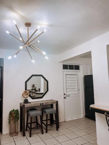 Una habitación con un espejo y una mesa con taburetes. en Villa seda, en Rincón