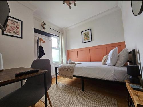 a bedroom with a bed and a desk and a window at Saint Margaret's Guest House - Comfortable Rooms in a Quiet Area Close to the Heart of Poole - Free Parking & Fast Wifi in Poole