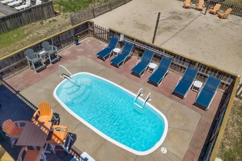 an overhead view of a swimming pool with blue lounge chairs at 4749 - Salty Dawgs in Kitty Hawk Beach