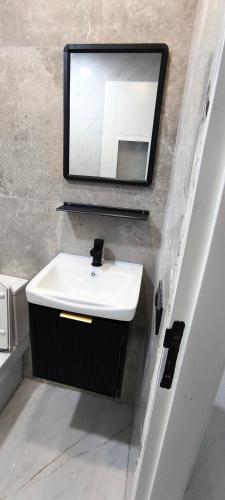 a bathroom with a sink and a mirror at Magnifique appartement de trois chambres, Résidence Kabila Vista in M'diq