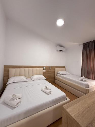 a bedroom with two beds with towels on them at Hotel Margjokaj2 Velipoje in Velipojë