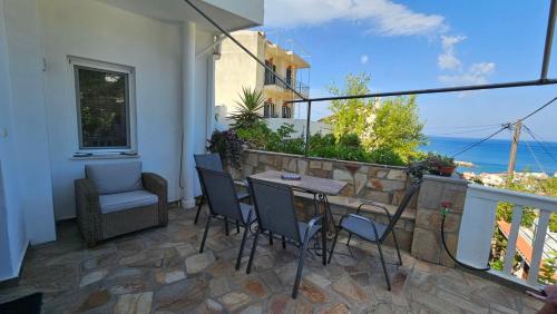 a patio with a table and chairs on a balcony at Raptis House in Karavostamo