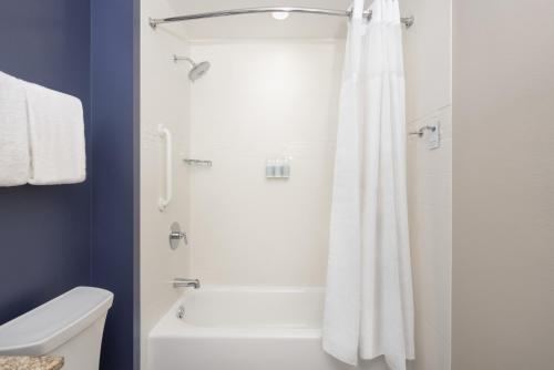 a bathroom with a shower with a white shower curtain at Residence Inn by Marriott Orlando Downtown in Orlando