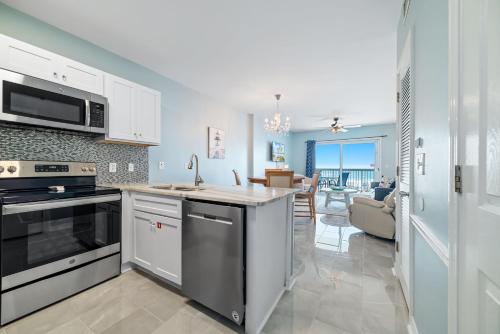 a kitchen with a stove top oven next to a living room at Caribbean Unit 103 in Gulf Shores