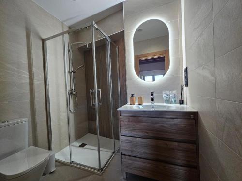 a bathroom with a shower and a sink and a mirror at Villanueva 5 in Luces