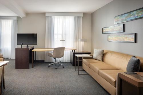 a living room with a couch and a desk at Residence Inn by Marriott Orlando Downtown in Orlando