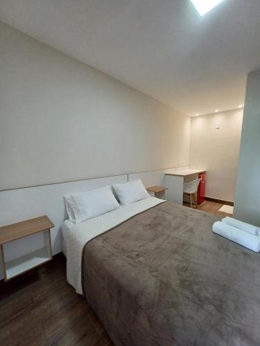a bedroom with a large bed and a desk at Riviera Sanary 1208 Nova Almeida in Serra