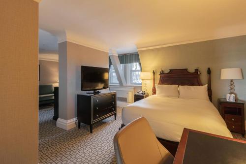 a hotel room with a bed and a television at Fairmont Chateau Laurier in Ottawa