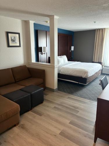 a hotel room with a bed and a couch at Comfort Inn & Suites Dayton Northwest - Englewood in Dayton