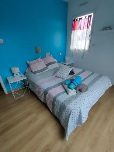 a bedroom with a bed in a blue room at chambre Chez sylvie in Allaire