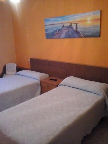 a hotel room with two beds and a painting on the wall at Hostal O Choyo II in Ferrol