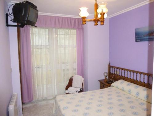 a bedroom with a bed and a tv on the wall at Hostal O Choyo II in Ferrol