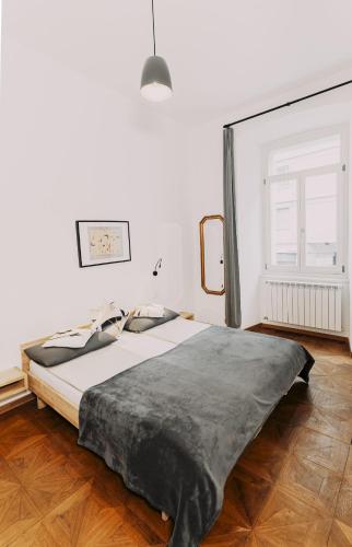 a large bed in a white room with a window at L'Arco Trieste studio living 1 in Trieste